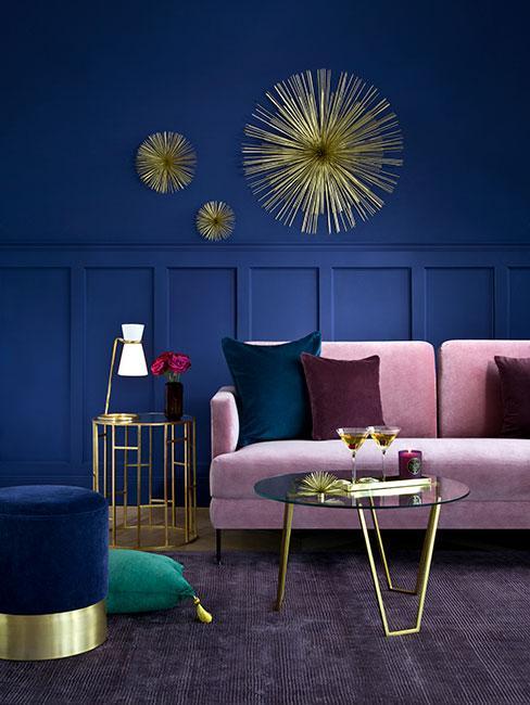 Salon avec mure bleu foncéet décoration murale, feuteuil en velours rose clair décoration dorée