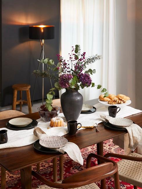 décoration de table avec assiettes noires et beige sur une table en bois foncé