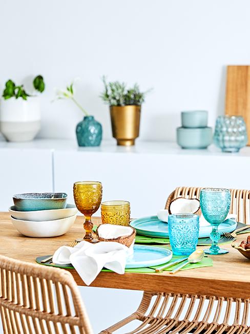 table en bois avec assiettes et verres turquoises