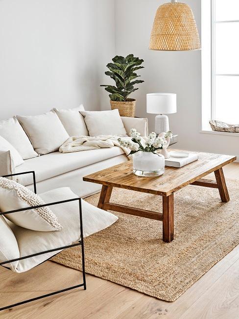 Salon avec tapis en jupe, table basse en bois et canapé blanc
