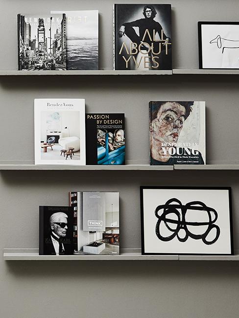 étagère avec livres et cadres accroché sur un mur gris