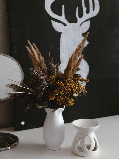 Mur peint en noir avec de la peinture ardoise, console blanche, vase blanc, bouquet de fleurs
