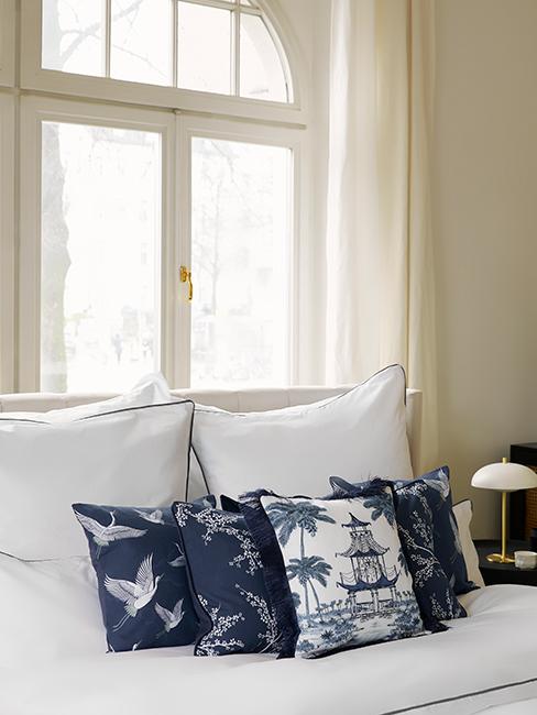 chambre avec linge de lit blanc et coussins décoratifs bleus orientaux