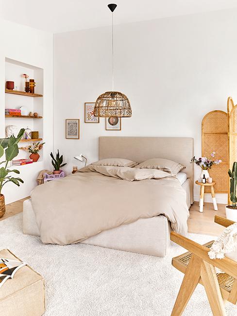 chambre avec grand lit avec couette beige et déco boho