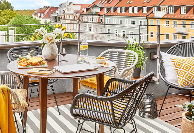 balcon avec chaises grises et plaid jaune