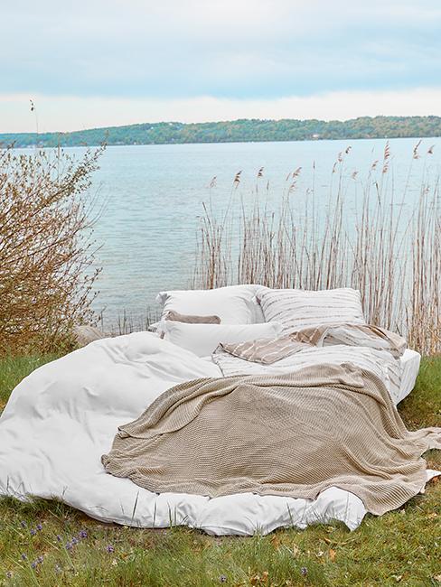 lit posé sur l'herbe près d'un lac