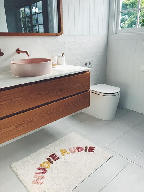 toilette avec tapis de sol et meuble en bois