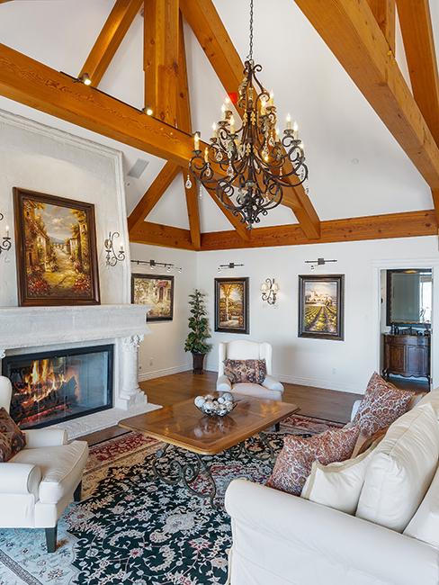 salon chic avec canapé beige, cheminée, poutre apparente et lustre