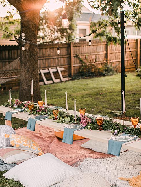 table extérieur dressée avec nappe, décoration de table et bougie dans le jardin