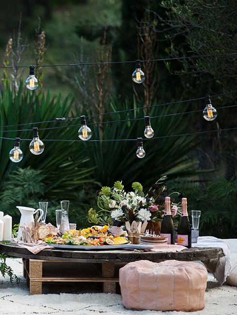 table avec apéro, guirlandes lumineuses dans le jardin