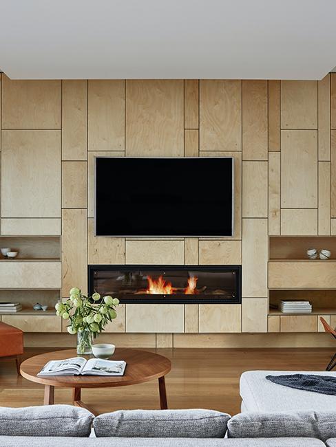 salon avec mur en bois, cheminée et télé