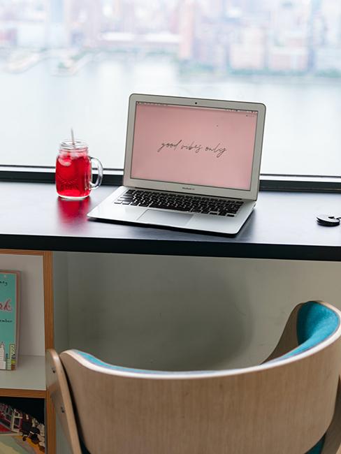 ordinateur avec boisson posé sur une table