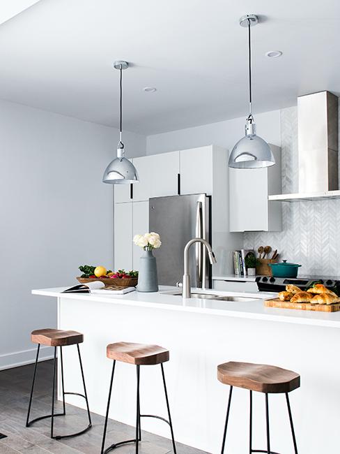 cuisine blanche avec tabouret en bois et suspensions en métal
