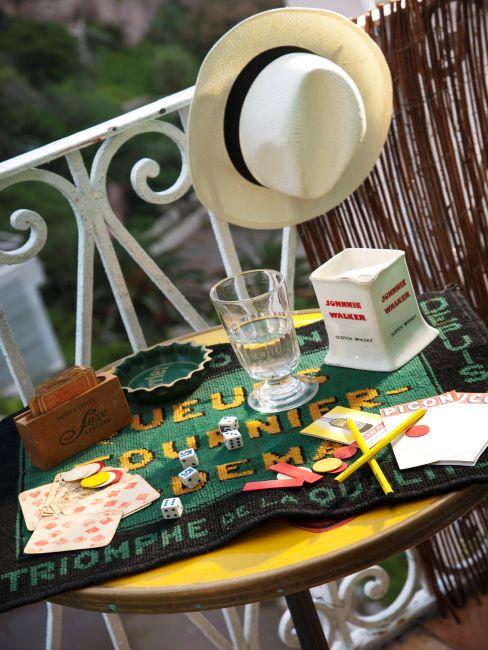 gros plan sur une petite terrasse, table en fer, jeux de cartes