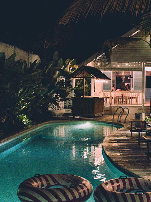 piscine avec bouées donut et bar dans la nuit