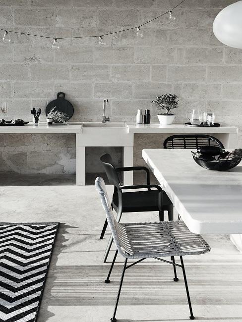 cuisine extérieur avec mur en brique, chaises ajourées, grande table