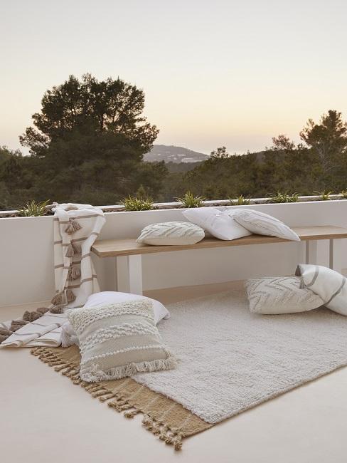 toit-terrasse avec bain en bois, tapis beige, coussins beiges