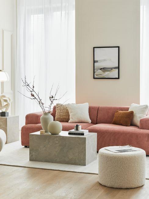 Salon écru, canapé rouge brique, table basse en marbre, vase écru, tableau, pouf