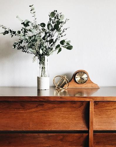 commode en bois, horloge, bouquet