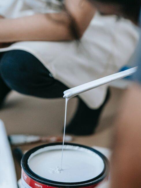 Zoom sur un pot de peinture et un baton mélangeur pour travaux de peinture