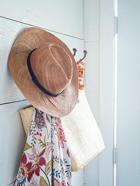 chapeau de paille accroché à un porte manteau