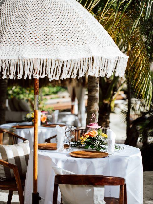 une petite table de mariage ronde, sous un parasol, mariage à l'étranger, mariage exotique