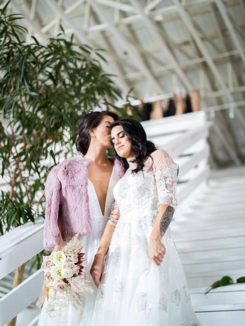 mariées portant des robes blanches de mariage avec un petit manteau en fausse fourrure lilas idéal pour un mariage en hiver