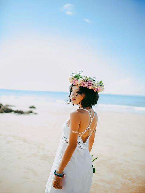 la mariée en couronne de fleurs sur la tête pose à la plage