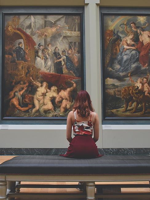 personne entrain de regarder des tableaux au musée du louvre