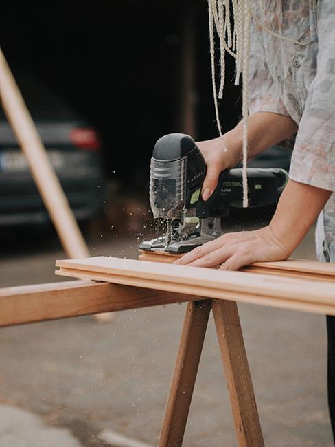 personne entrain de percer une planche de bois