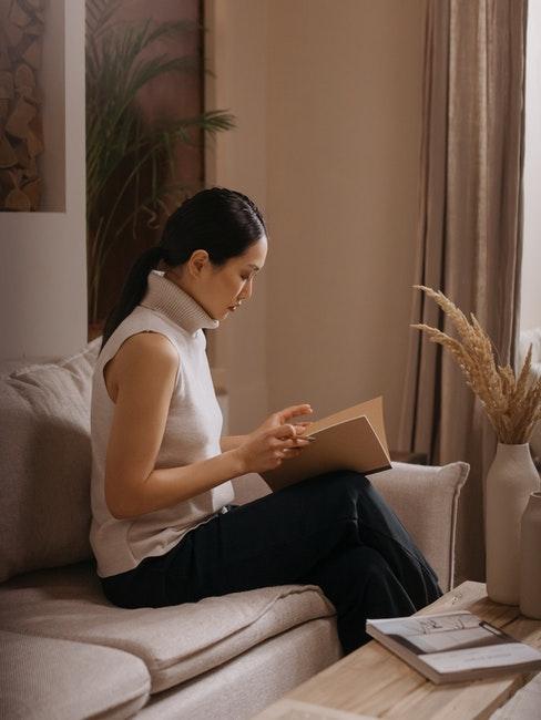 femme qui lit sur un canapé scandi