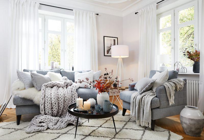 salon d'automne avec canapégris, couvertures et déco d'automne