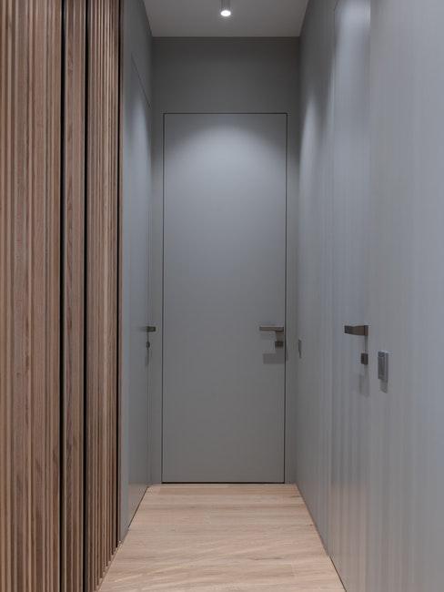 Petite entrée d'appartement avec armoire en bois intégrée et murs ris