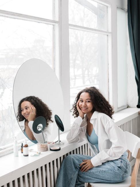 jeune fille faisant sa toilette devant une grande fenêtre