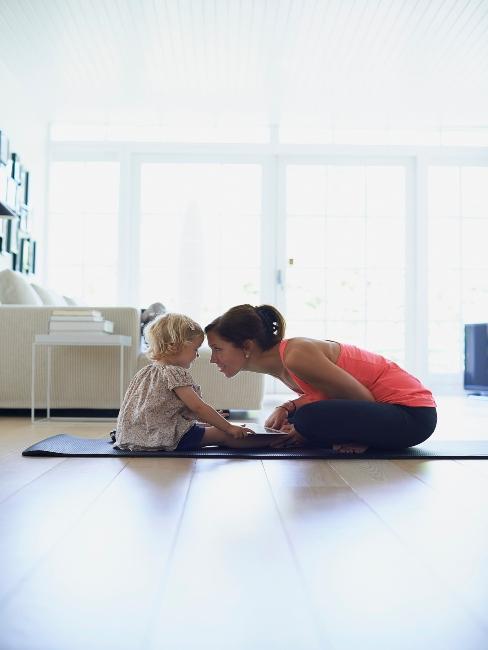 jeune maman avec son enfant sur un tapis pour yoga