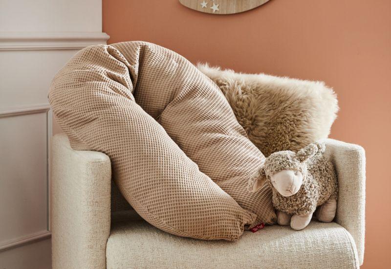 coussin de grossesse sur fauteuil beige et doudou mouton 1