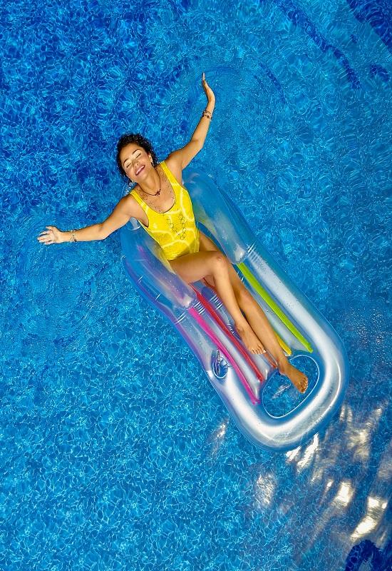 femme au maillot de bain jaune sur une bouée dans une piscine