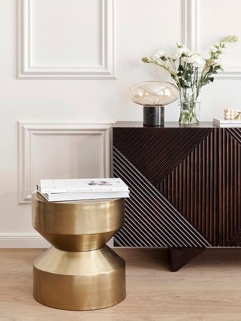zoom sur un pouf effet laiton et un buffet bois foncé texturé