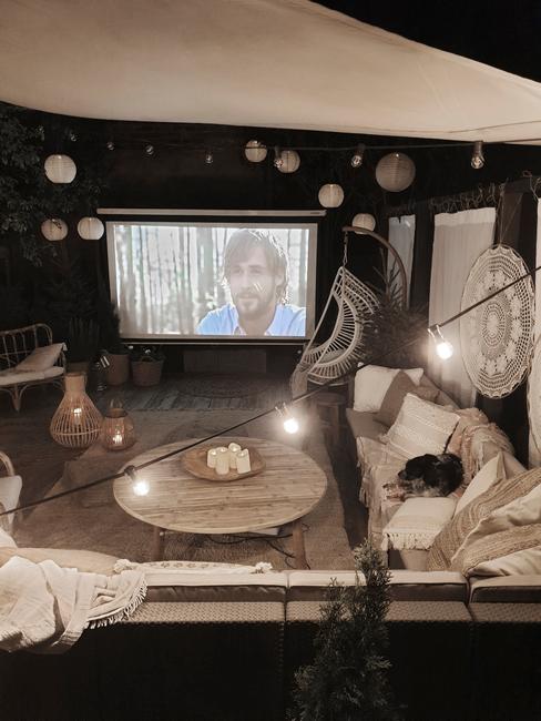 terrasse avec en été, soirée, avec guirlande lumineuse, salon de jardin et drap blanc pour projeter un film