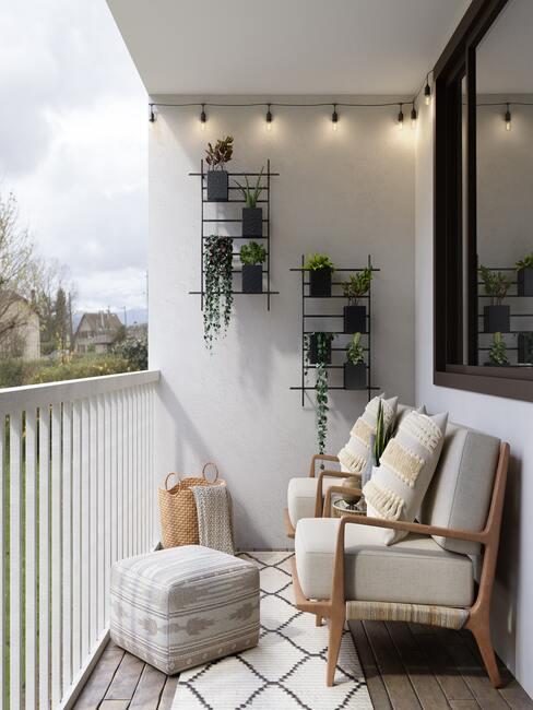 balcon avec mur blanc, salon de jardin en bois, étagères noires avec des plantes