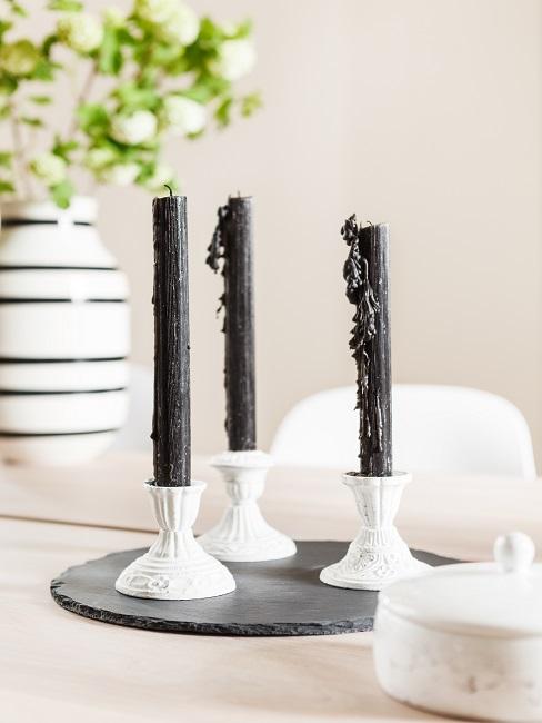 bougies noires sur bougeoirs moulés blancs