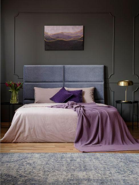 chambre avec murs gris foncés, tête de lit grise, tapis gris, parquet, coussins et plaid couleur very peri