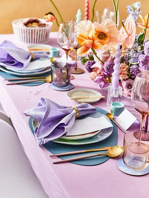 table dressée. colorée avec nappe rose, set de table vert, serviette very peri, fleurs et bougies