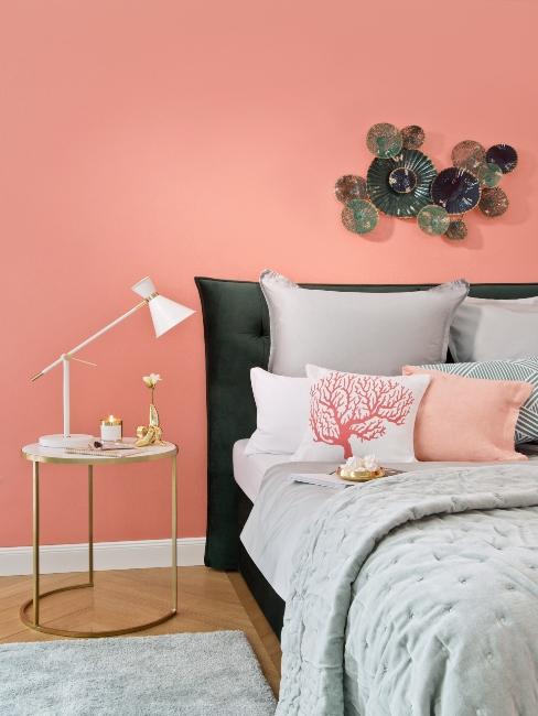 chambre à coucher avec mur de couleur corail et linge de lit gris