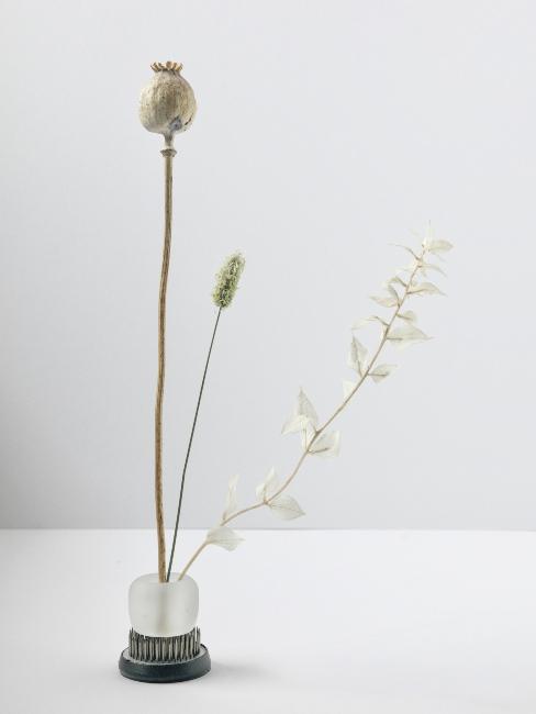 bouquet ikebana minimaliste dans un petit vase en verre