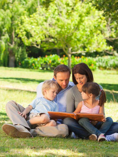 famille regardant un album photo dans un parc