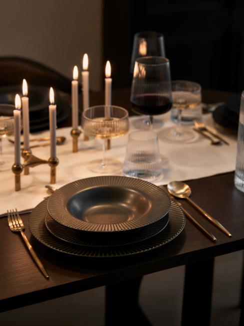 table dressée avec assiettes noires et couverts dorés