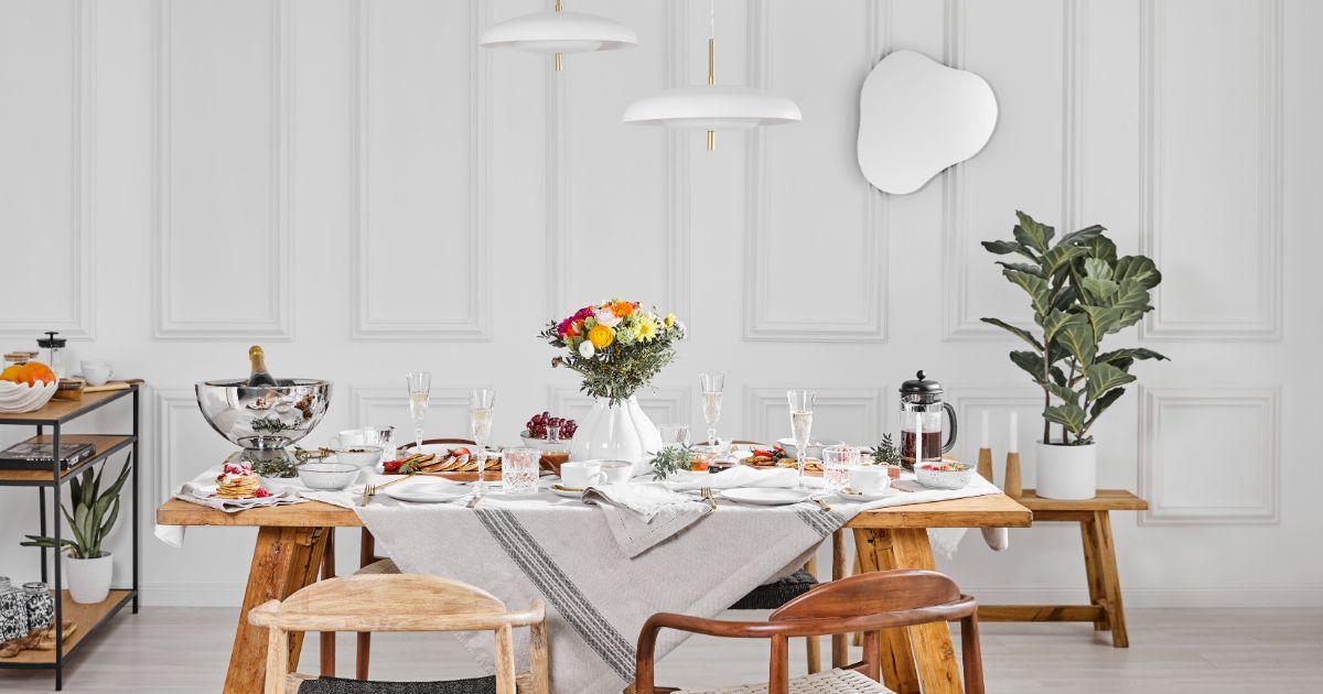 Salle à manger table vase blanc bouquet rose jaune nappe blanche liseré foncé couverts