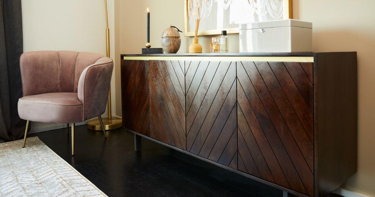 Commode design en bois foncé et détails dorés fauteuil rose poudré velours