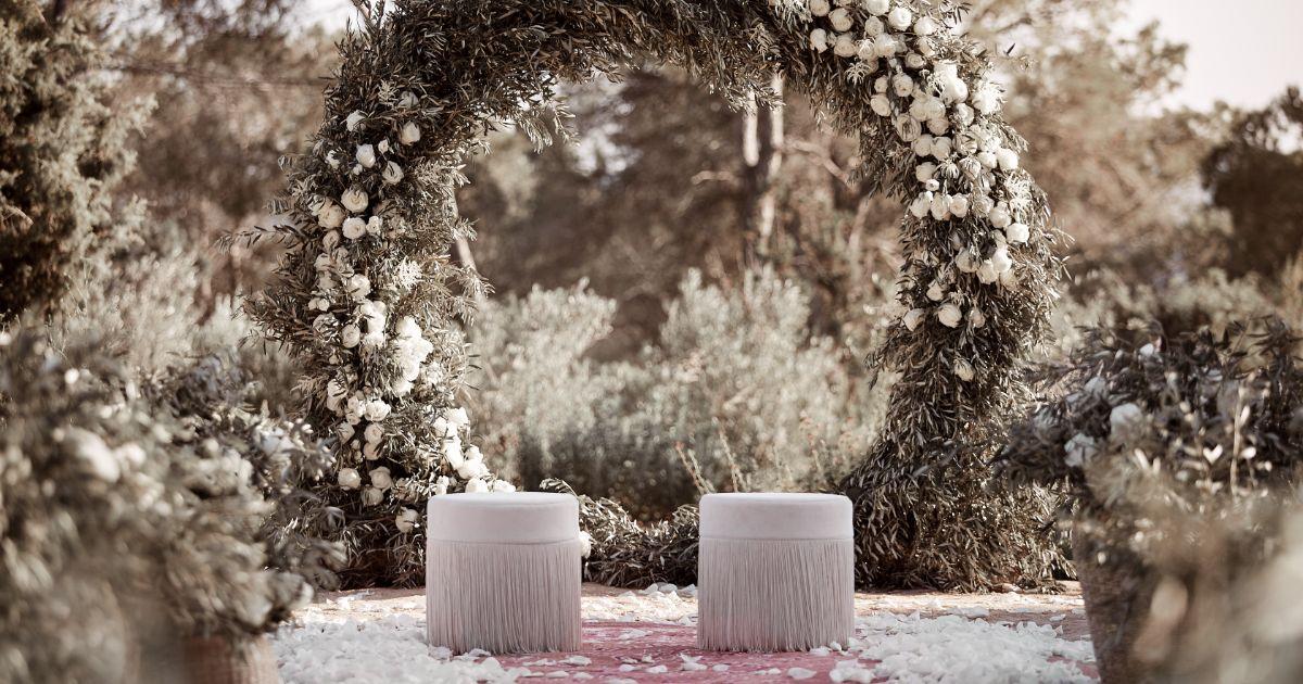 décoration de mariage avec arche et pouf crème